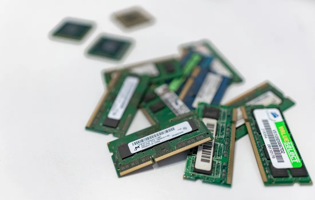 Assorted desktop and laptop memory modules with processors on a white surface